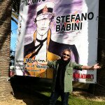 STEFANO BABINI CONTEMPLA IL BANNER DELLA MOSTRA